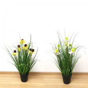 Närmare 2 natur konstgjord lökgräsväxt i dekorativ planteringsinredning